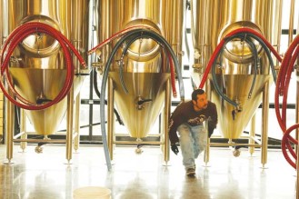 A worker cleans brewing tanks