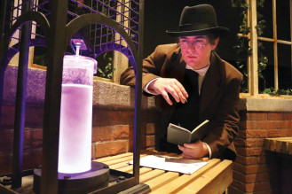Historical reenactor Andrew Parker portrays Victorian-era journalist Nathaniel Becker. The experiment reveals the identity of an unknown substance by turning a clear liquid to lavender.