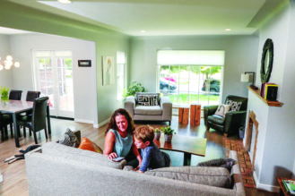  Jaime Arruda and her son Theo, 10 sit in the living room of their Tudor style home on Glencoe Street. The skylights, large windows and open floor plan create lots of natural light throughout the home. 