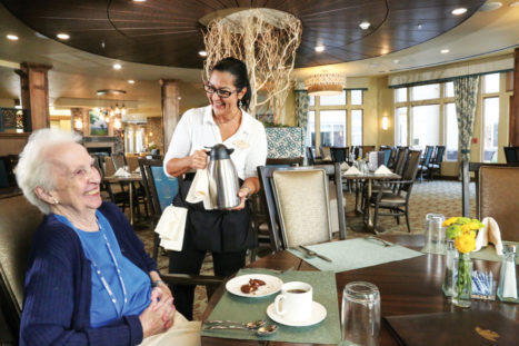 Resident Jo Eaton shares a laugh with Liz Garcia in the Rosemark dining room.