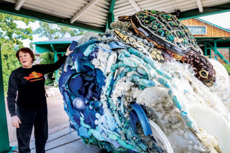 Pozzi is shown with “Natasha” the sea turtle who is riding a wave of plastic bags that look like seafoam in the sculpture.
