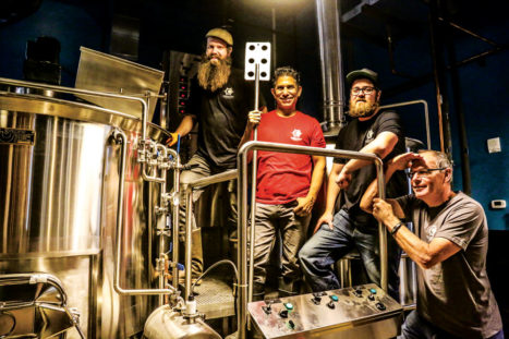 Javier holds a paddle from the mash tun as brewery consultants Austin Wiley (left) and Darren Boyd from Spangalang Brewery and Charlie Krupanszky (far right) pause from their work.