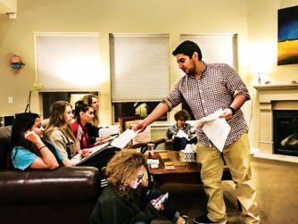 At the night-before-competition prep session, DSST’s Eesam Hourani hands out papers to Ruja Parikh, Isabell Horton, Erin Clark, Maeve Marley (on the couch), and Max Gregg (in the chair).