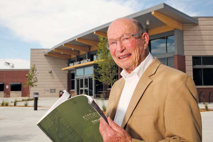 Sam Gary holds a copy of the Stapleton Development Plan (the Green Book) at the new Sam Gary library in August 2012. 