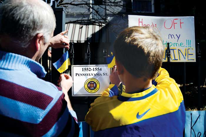 John Babiak and his son Marco put up Ukrainian flags at the Russian consulate. Photo by John Leyba/Denver Post