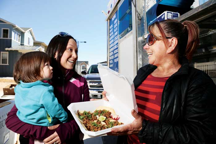 Conservatory Green resident Dee Dee Colussy and her 18-month-old daughter, Lily, stop for a quick lunch from Maria Lara of Lonchera La Reina Taco Truck—a favorite perk of residents living in the construction area. 