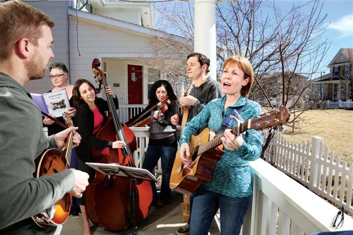 Members of the Stapleton Front Porch Jam play on the porch on a warm afternoon in March. Left to right: John Cooksey, Courtney Drake-McDonough, Emily Aronow, Laura Hockman, Manny Ladis and Windy Waite. 