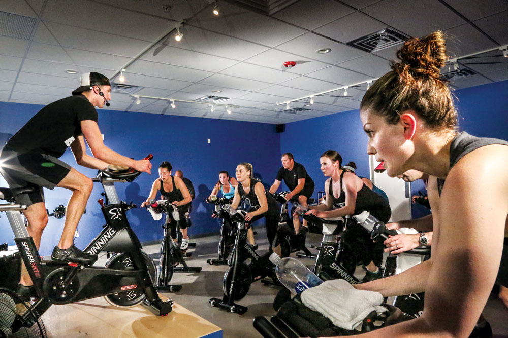 Danny MacDonald leads a spin/exercise session at the new Shift Cycle + Fitness Studio in Northfield. Owner Whitney Christensen is in the foreground above at right.