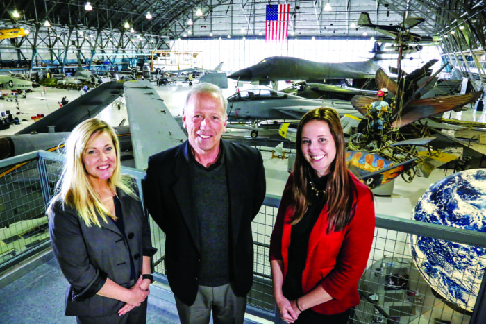 COO Mark Hyatt is flanked by Colleen Murray (left), director of marketing, and Heather McCallin, director of advancement, in this view of the Hangar One display floor. 
