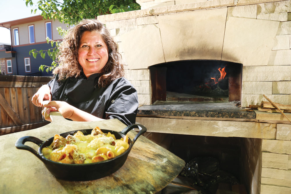 Elise Wiggins cooks in a wood-fired oven in the back yard of her Stapleton home.