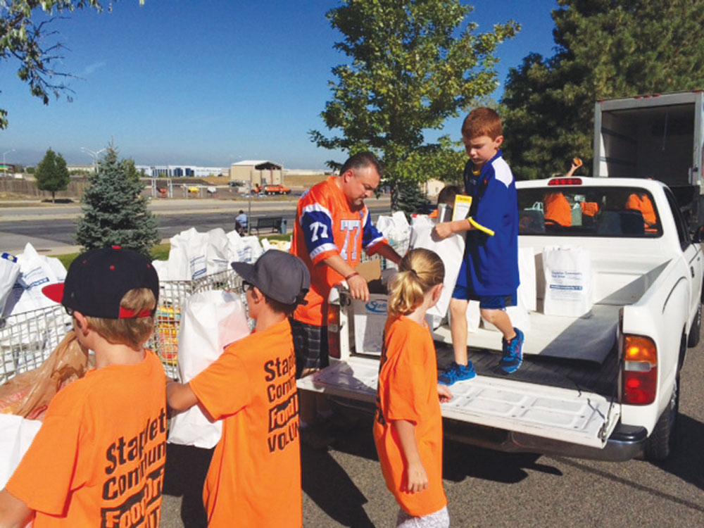 Students help collect canned goods from homes, then help load the trucks that take the food to Food Bank of the Rockies. Photo courtesy of Stapleton Food Drive.
