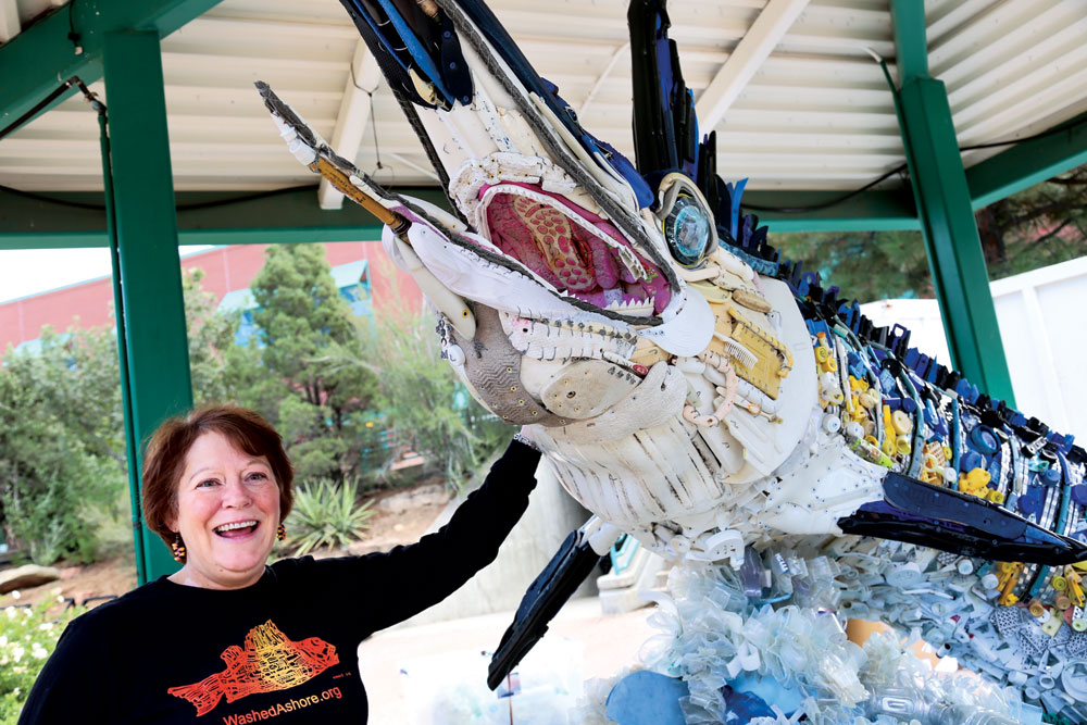 Artist Angela Haseltine Pozzi points to “Flash,” the marlin created from flotsam, including fishing poles, fishing lures, Hello Kitty flip-flops, and Tonka truck tires. 