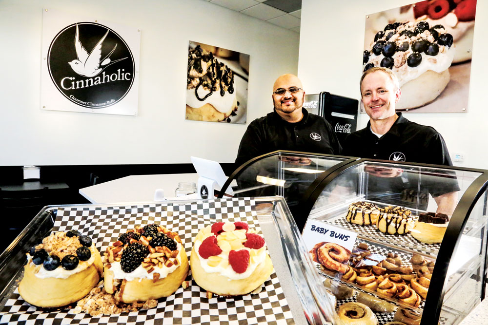 Jose Ramos, general manager (left) and owner Kyle Fabra show off some of their cinnamon rolls.