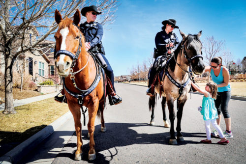 Bea Farrell, 4, and her mom, Brenna Farrell greet the officers and their horses.
