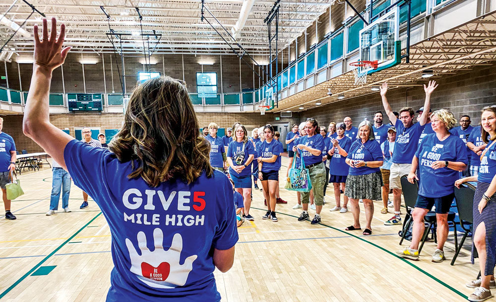 Denver First Lady Courtney Johnston gives instructions to volunteers (including her husband)  who gathered at the Hiawatha Davis Jr. Recreation Center to fill donated backpacks with pens, notebooks, and other supplies on the weekend before school started.