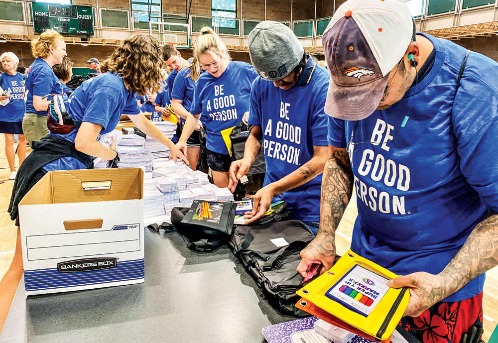 Volunteers at the inaugural Give5 Mile High event formed an assembly line to fill student backpacks with pencils, markers, and other supplies.