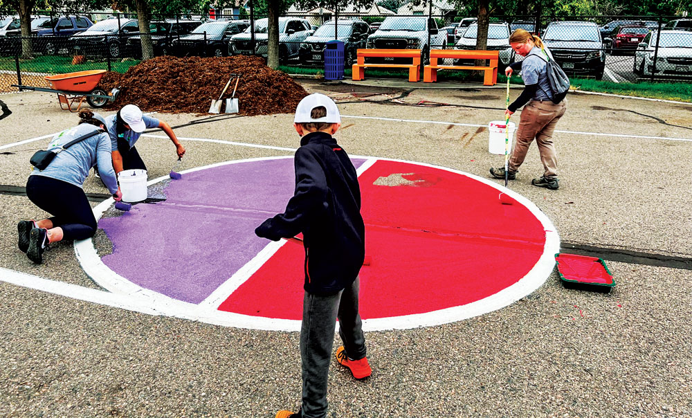 Volunteers paint the playground at Ashley Elembentary during the “Back to Class Bash”.